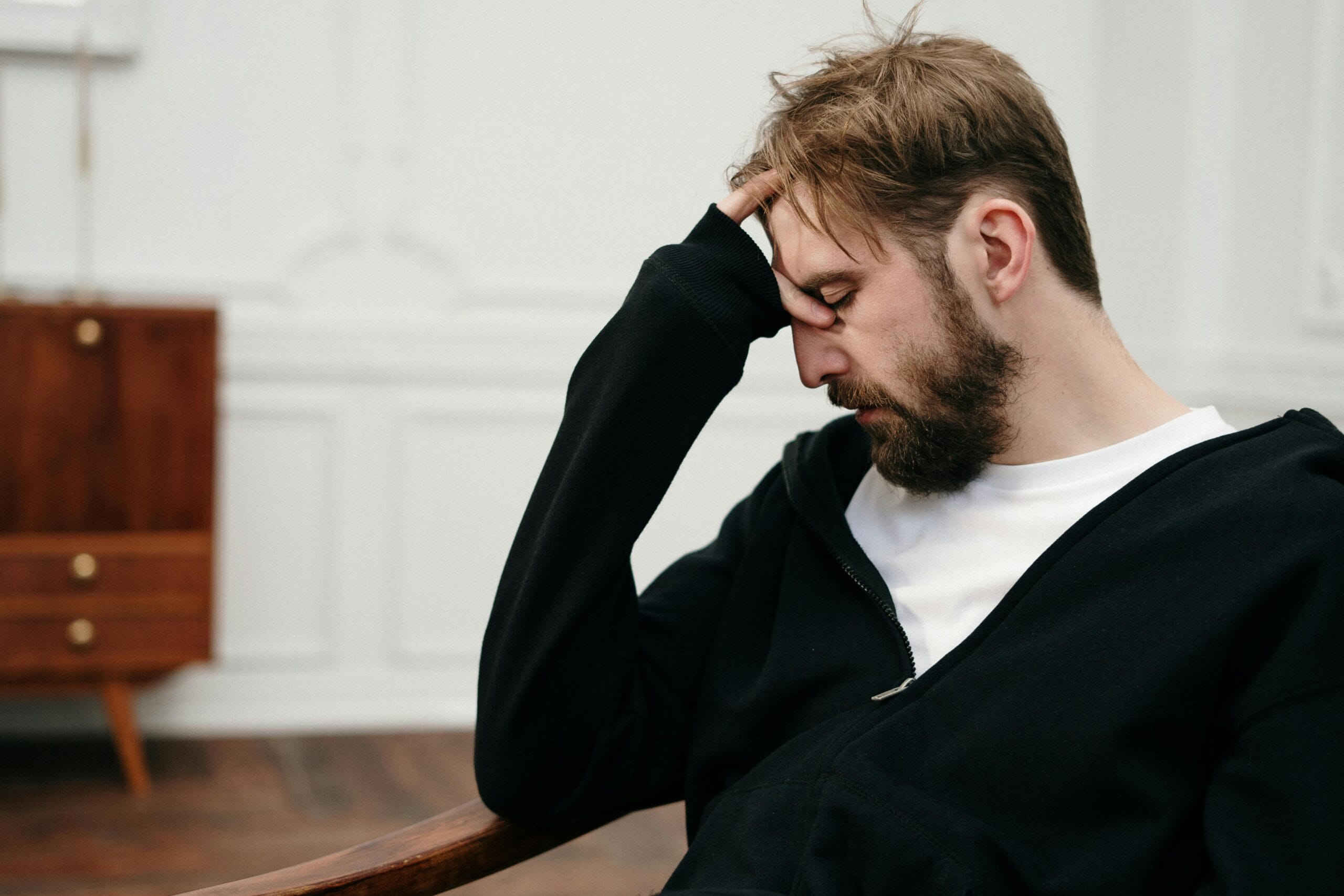 Man sitting with his head in his hand, looking distressed